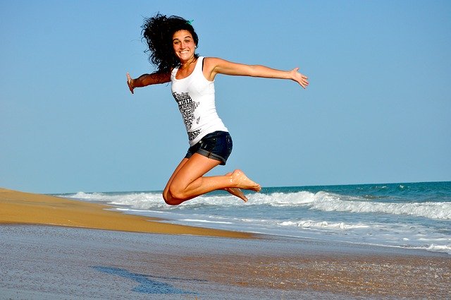žena skáče na pláži